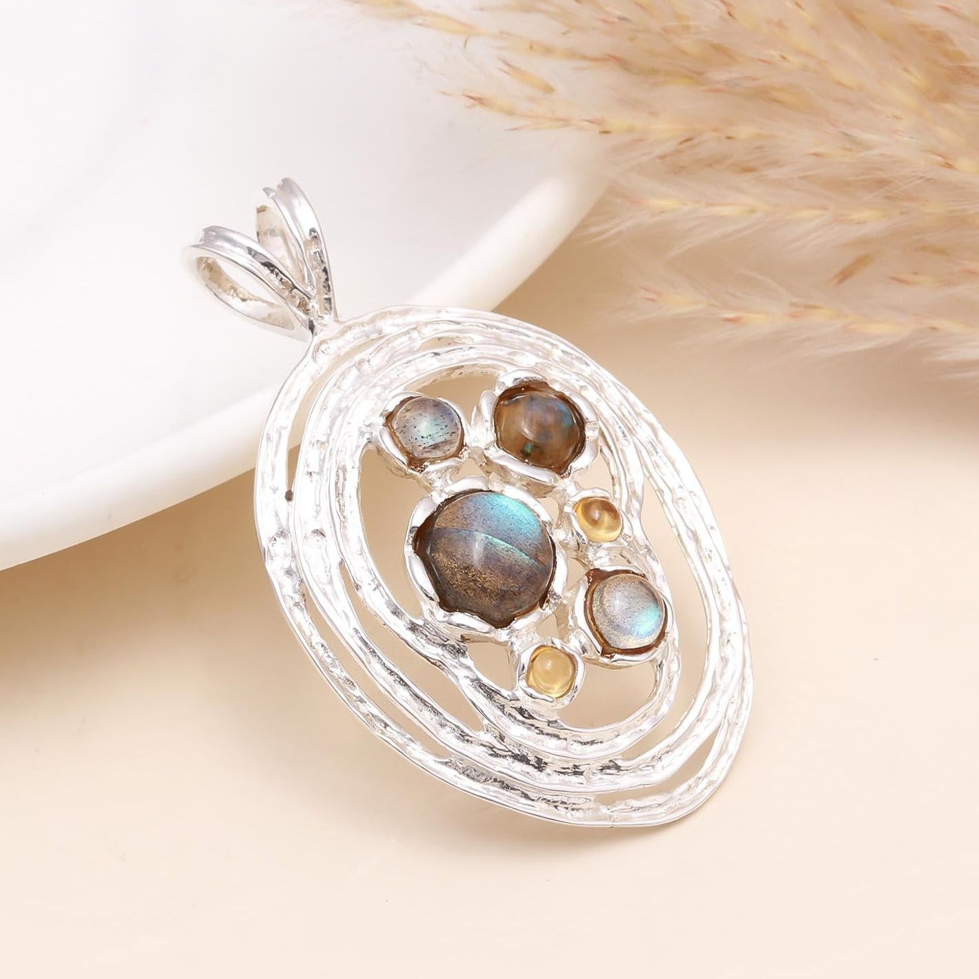 A sterling silver modern pendant featuring a labradorite gemstone with a golden citrine in a sleek design, displayed against a neutral background.
