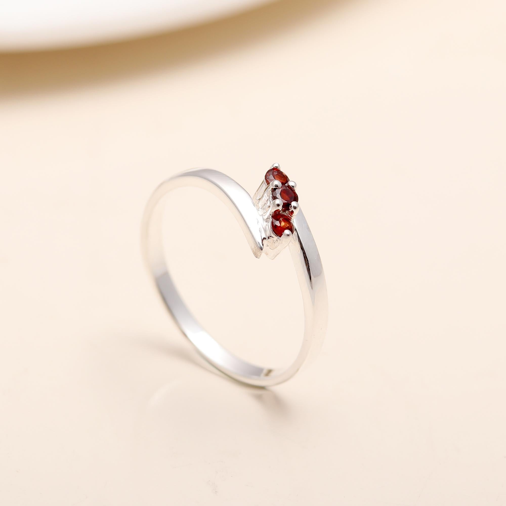 Elegant red garnet ring with overlapping silver bands