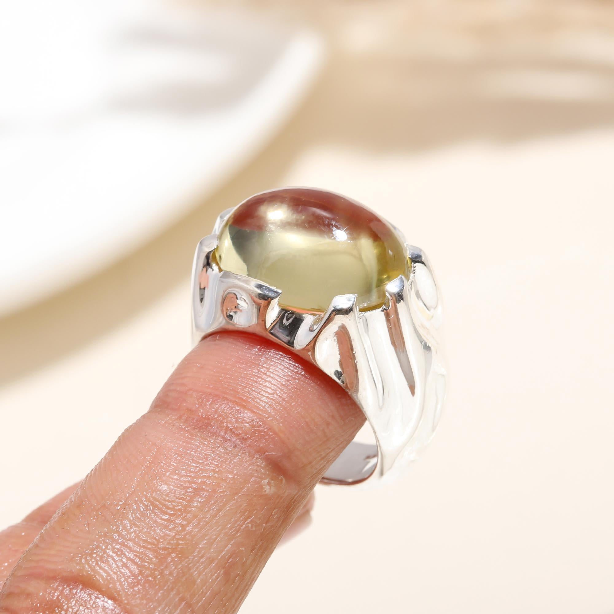 Elegant green amber cabochon silver ring on finger