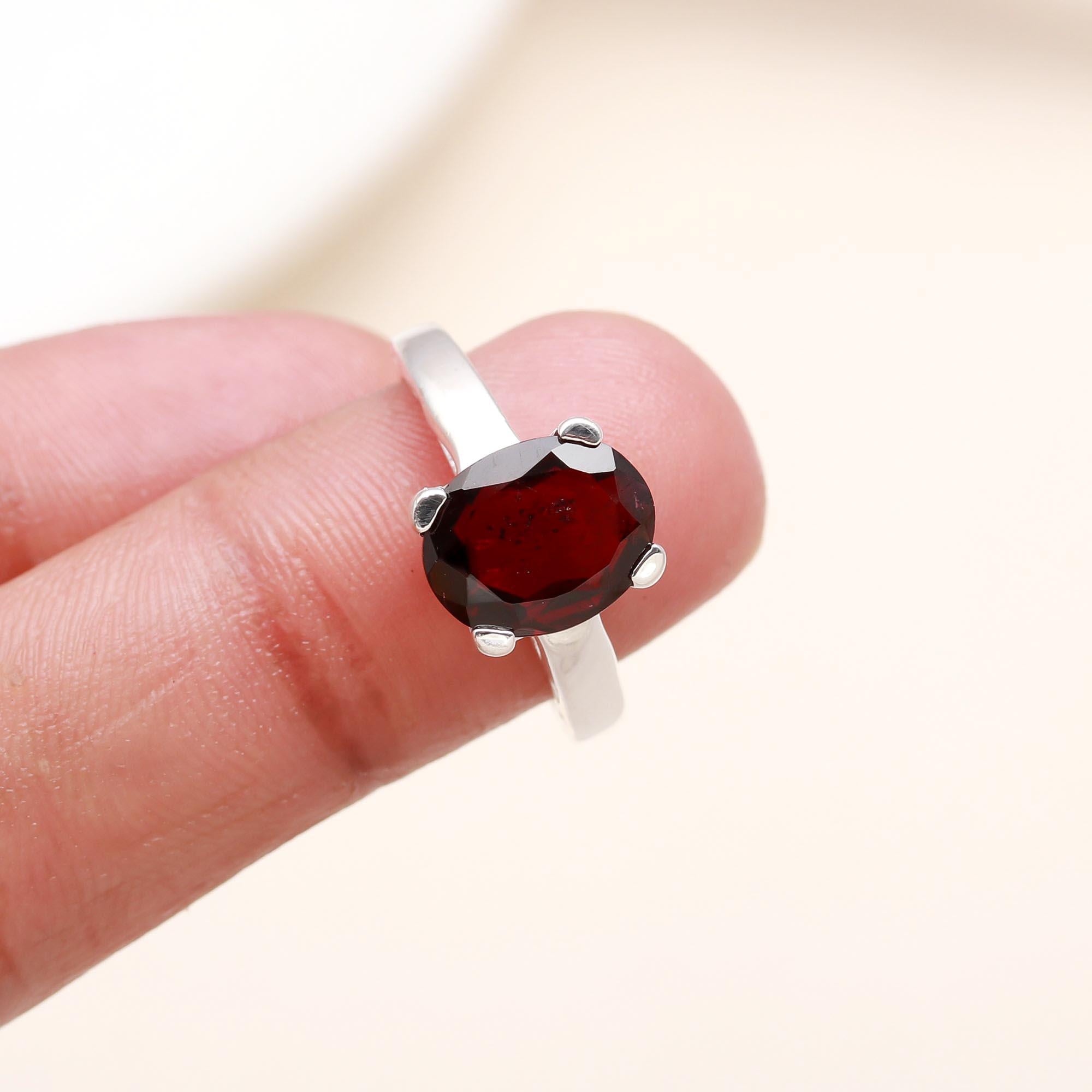 Elegant red garnet solitaire ring on finger