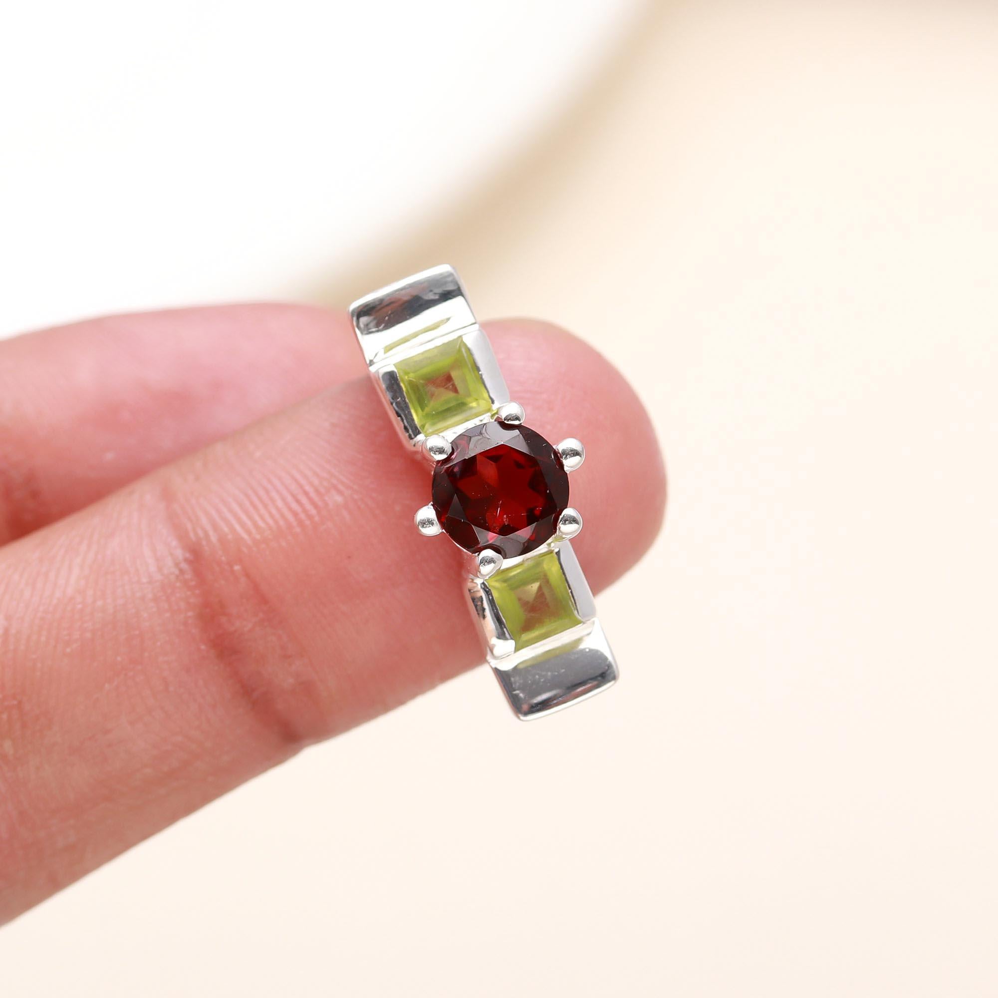 Elegant garnet and peridot square ring on finger