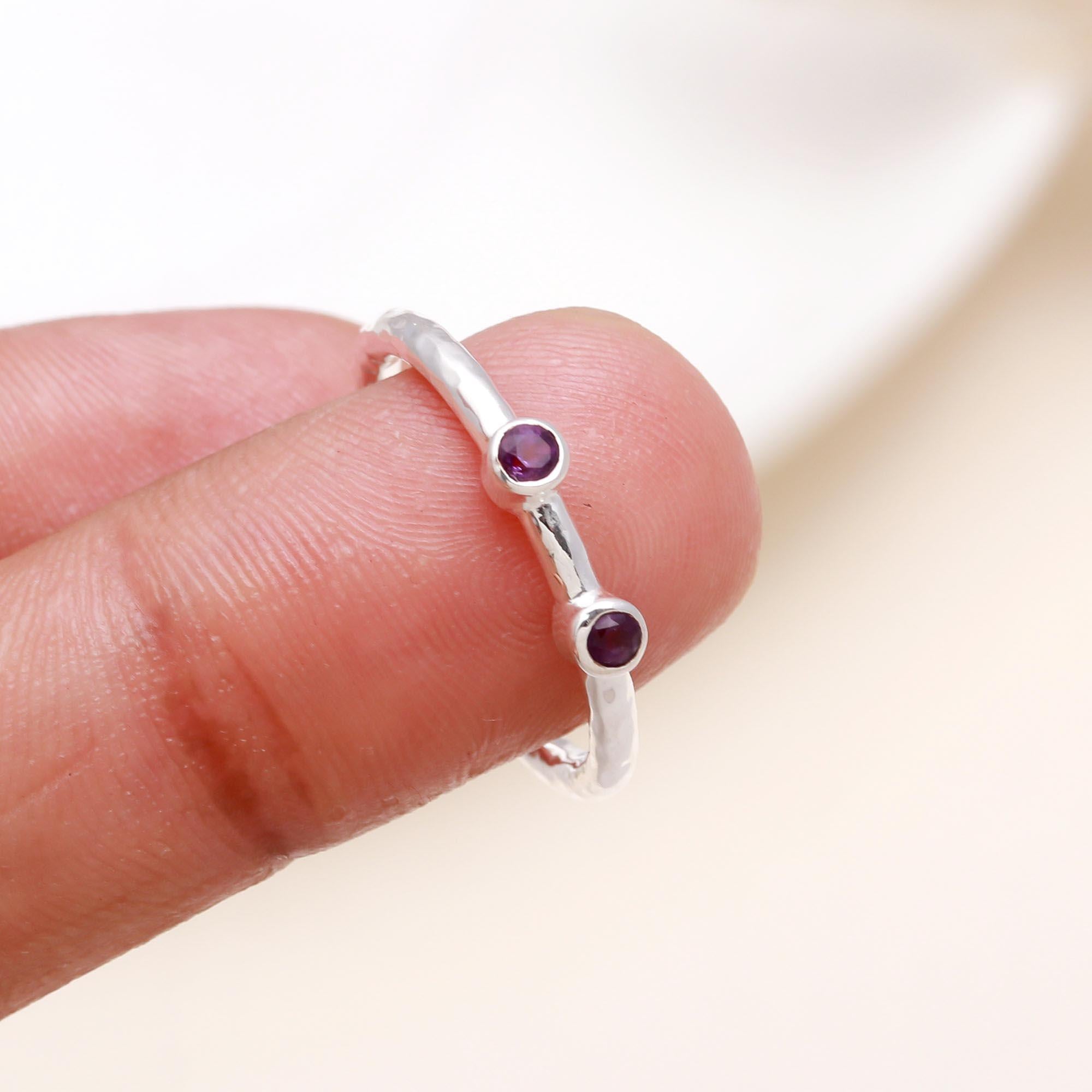 Twin amethyst gemstone ring displayed on finger