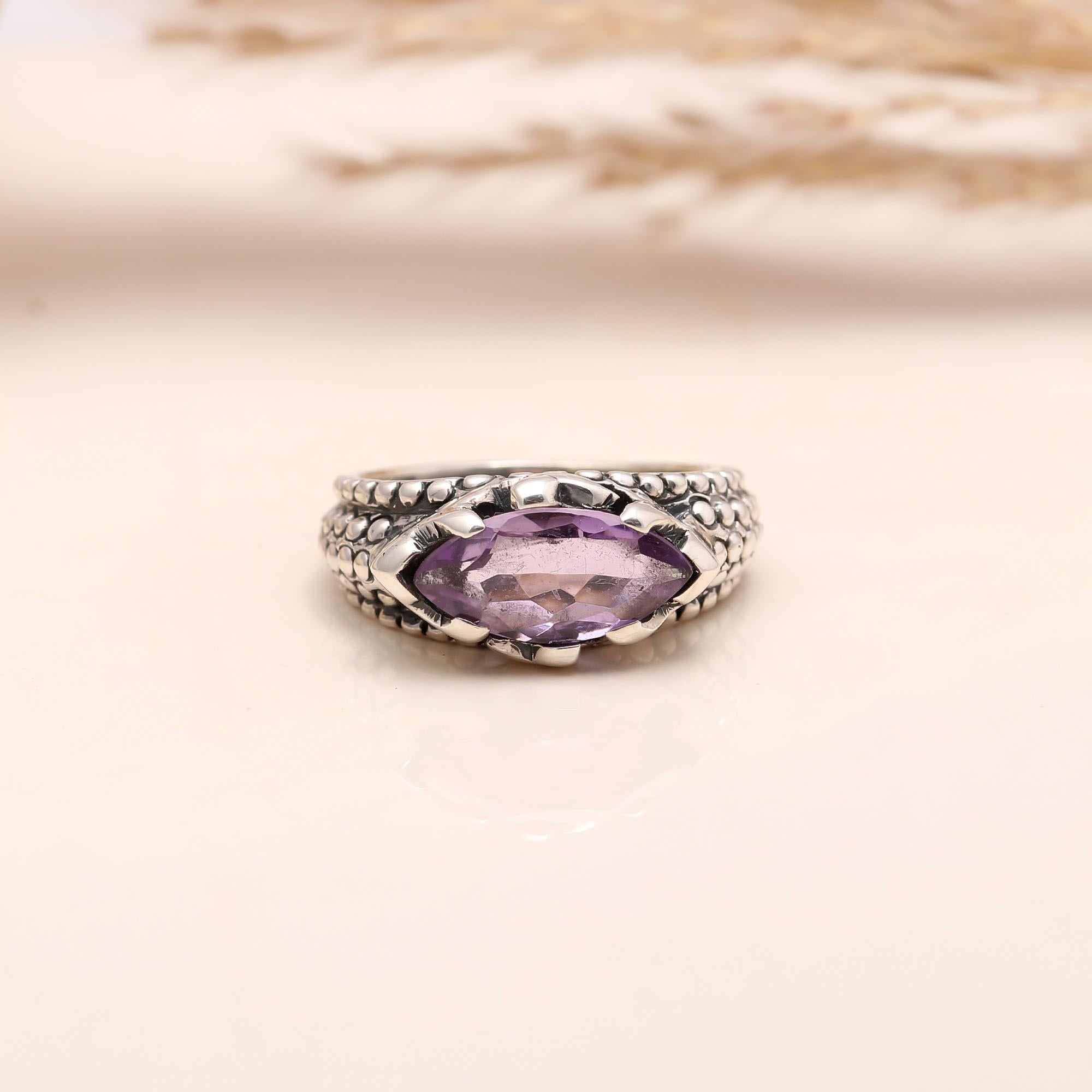 Close-up of marquise cut amethyst textured silver band ring