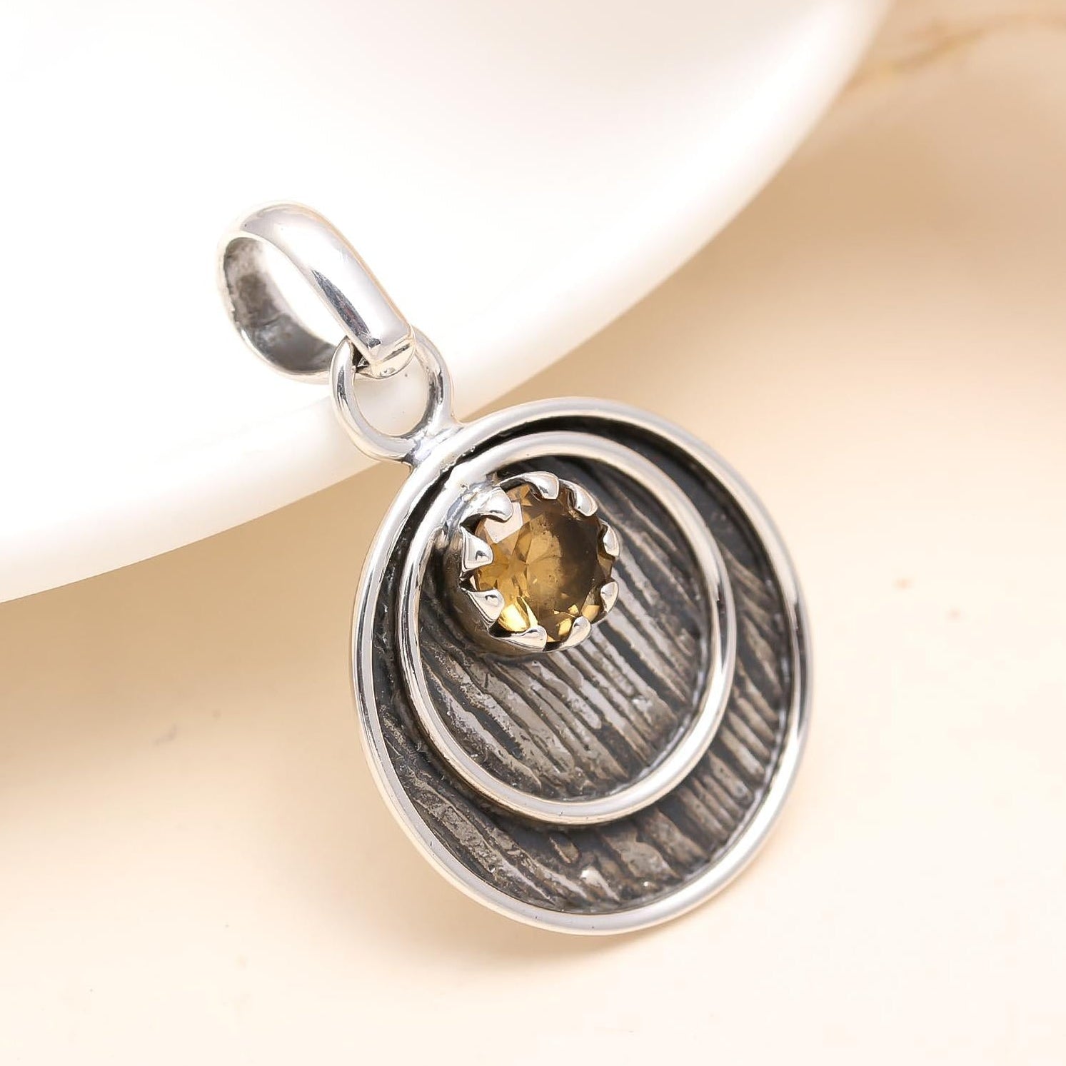 Silver pendant with a gold heart on a beige background
