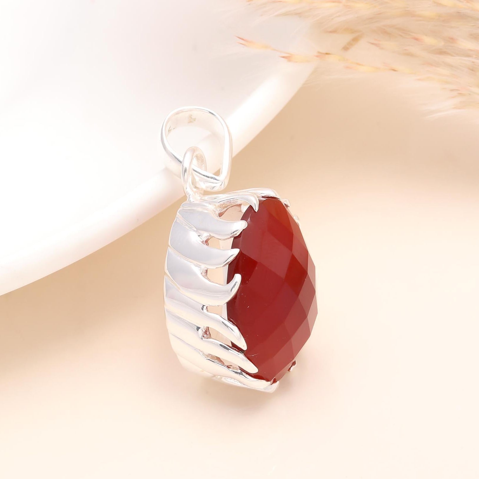 A 925 sterling silver bold pendant with a faceted carnelian gemstone, displayed against a light background.