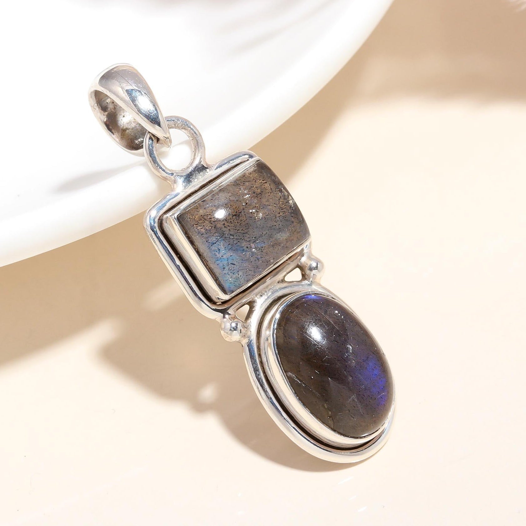 A 925 Sterling Silver pendant featuring two natural labradorite gemstones with a boho style setting.