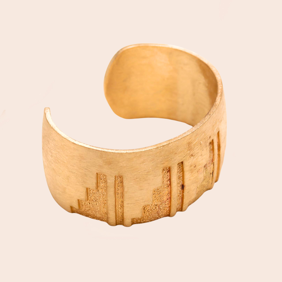 Golden 925 Silver bracelet with engraved design on a beige background