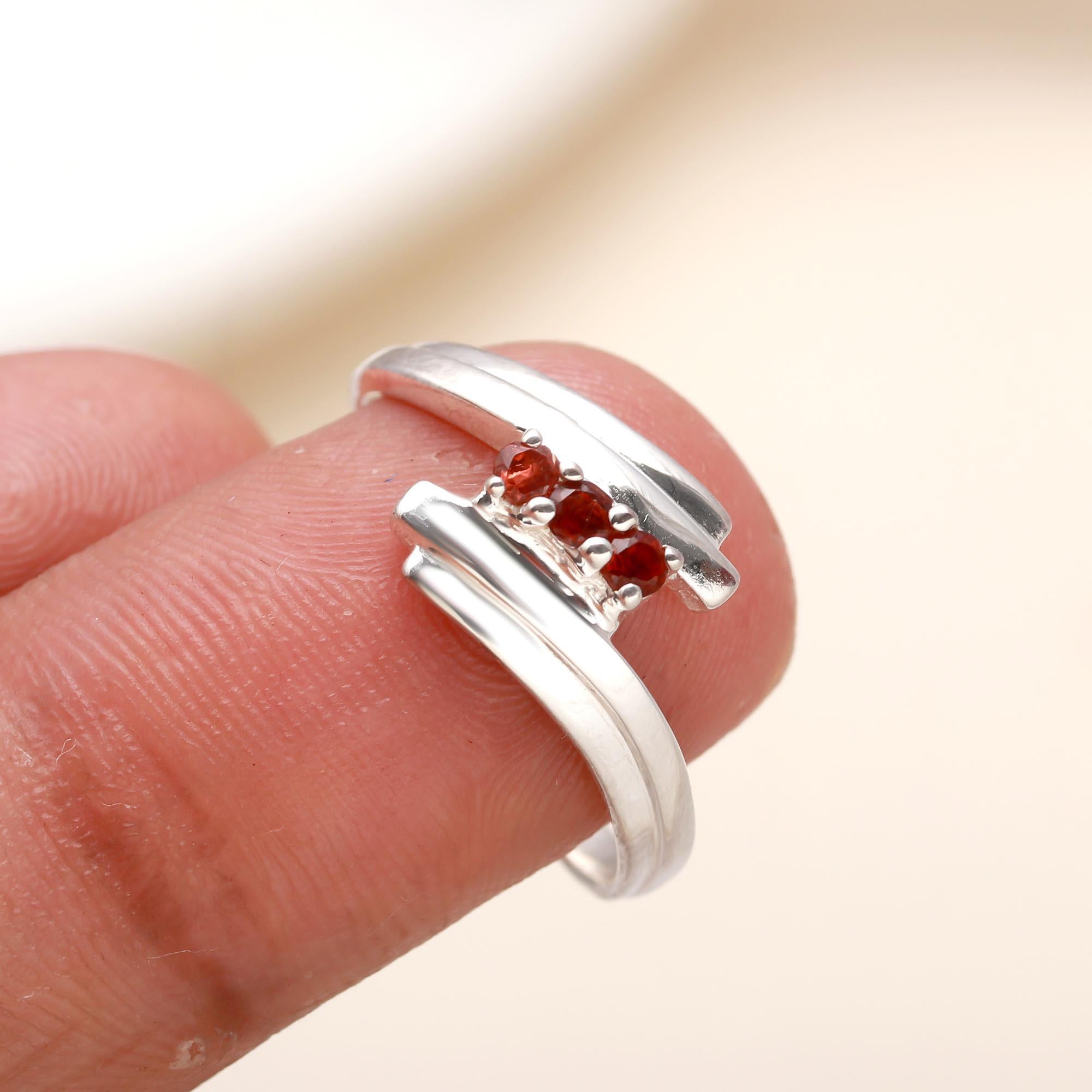 Handcrafted sterling silver bypass ring featuring garnet