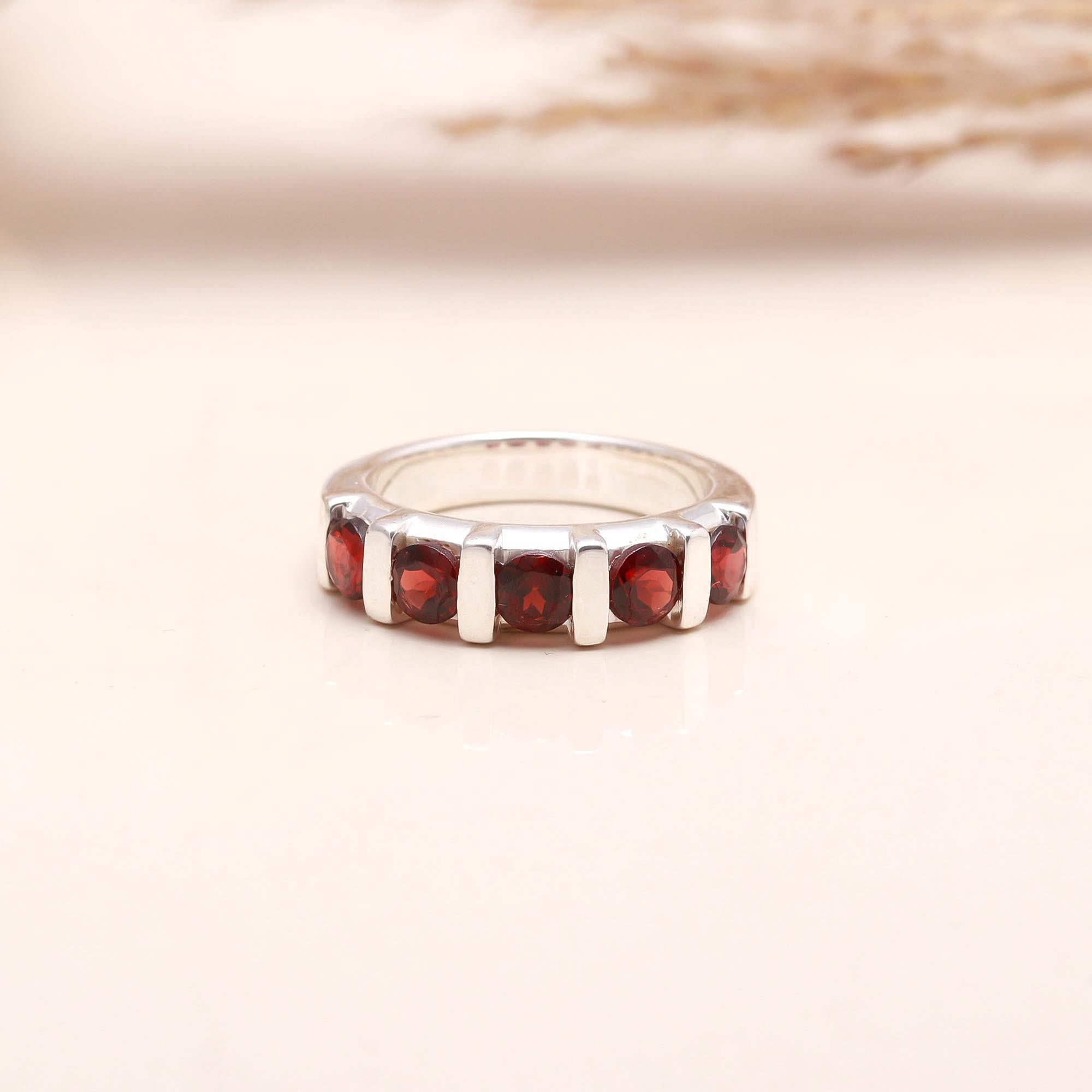 Close-up of red garnet half eternity silver band