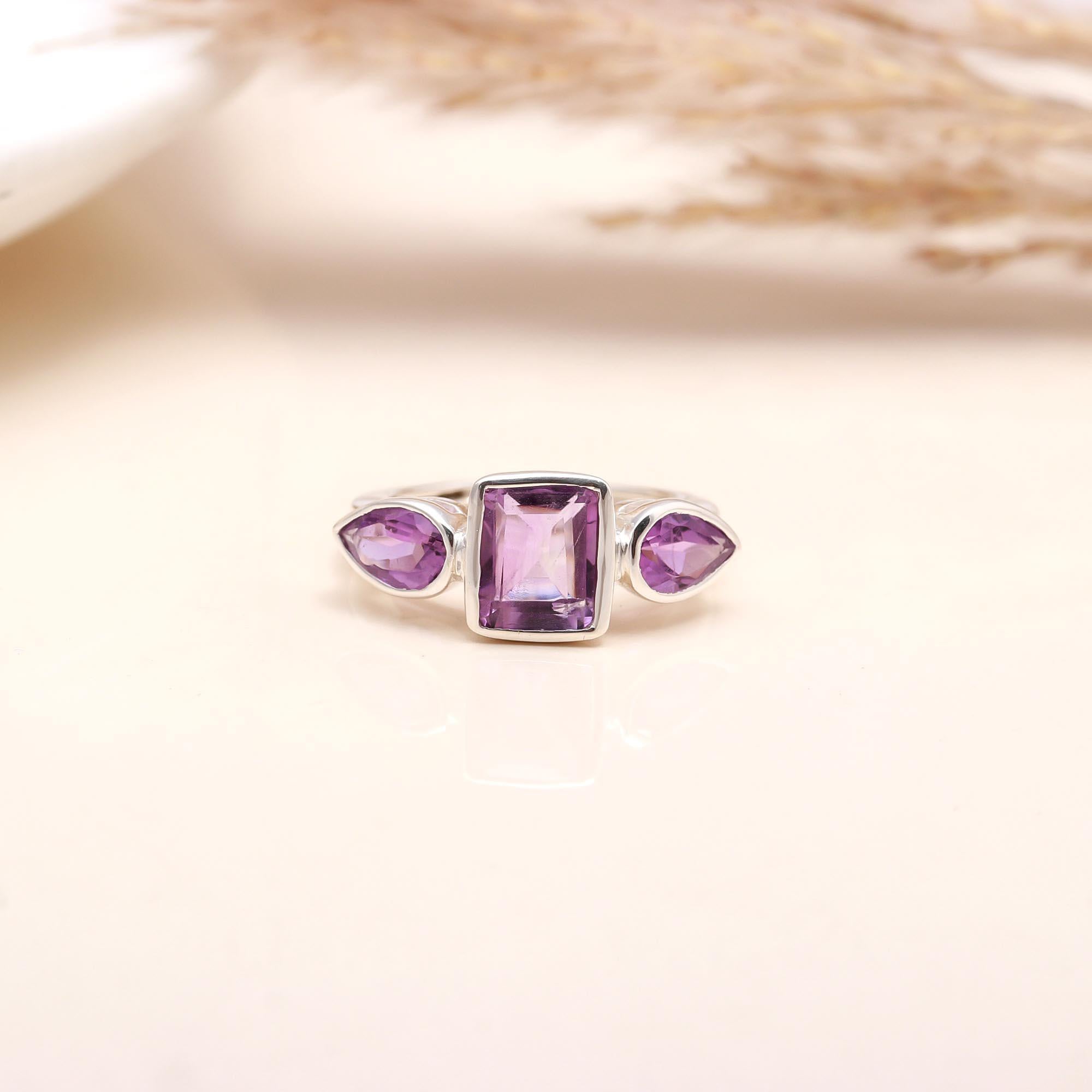 Close-up of pear and baguette amethyst silver ring
