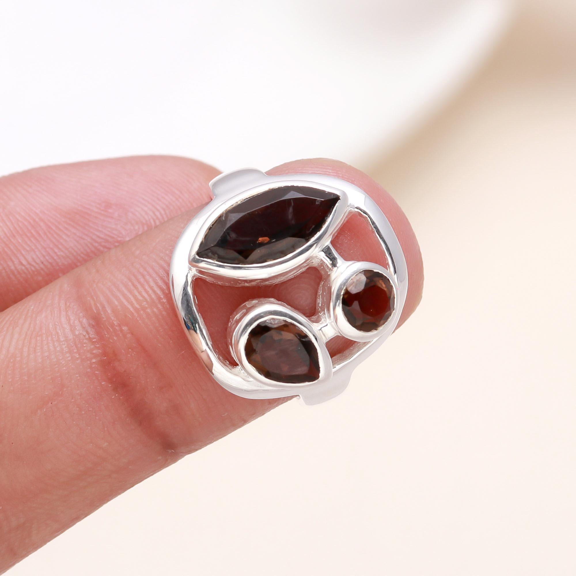 Garnet open-frame silver ring displayed on finger