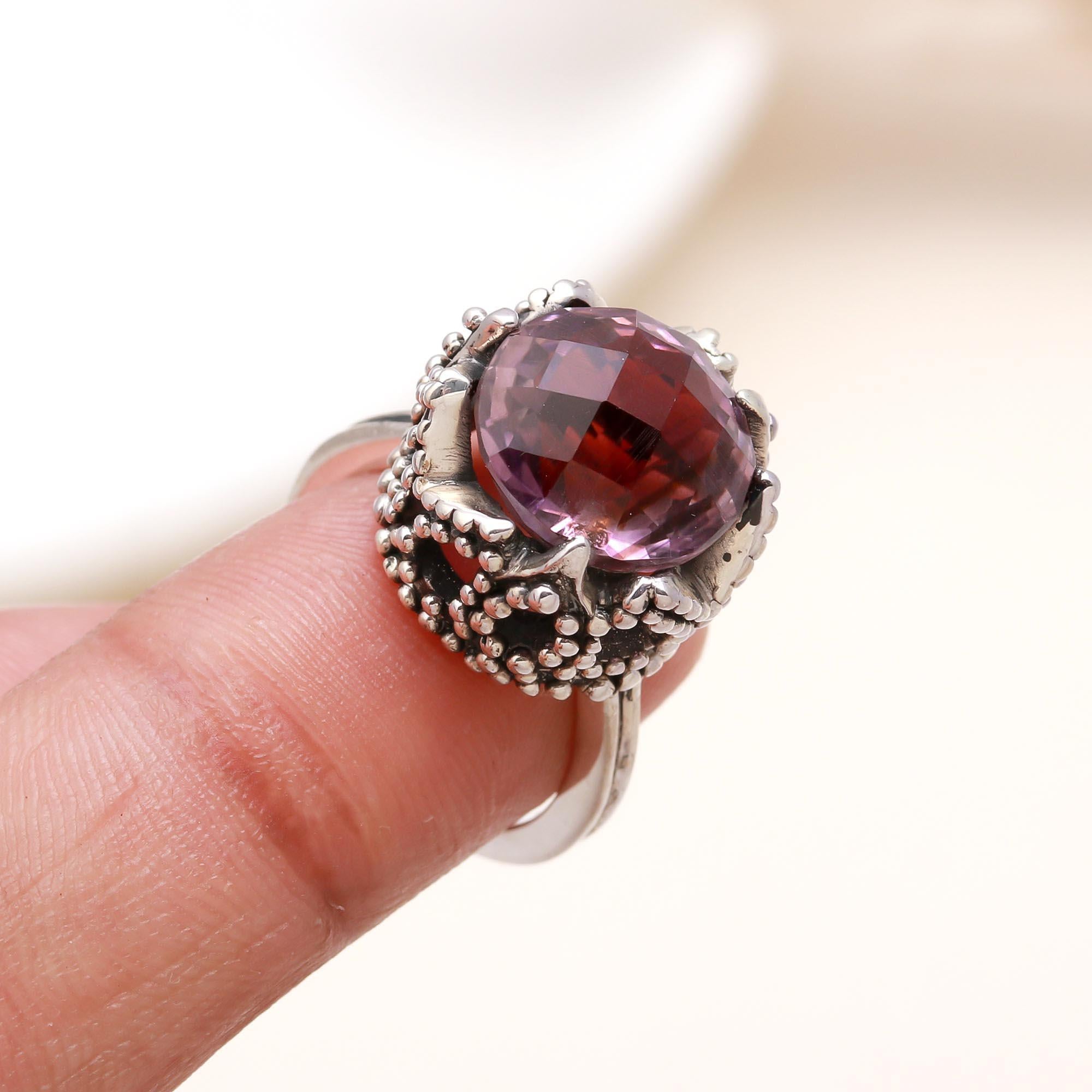 Elegant faceted amethyst gemstone ring on finger