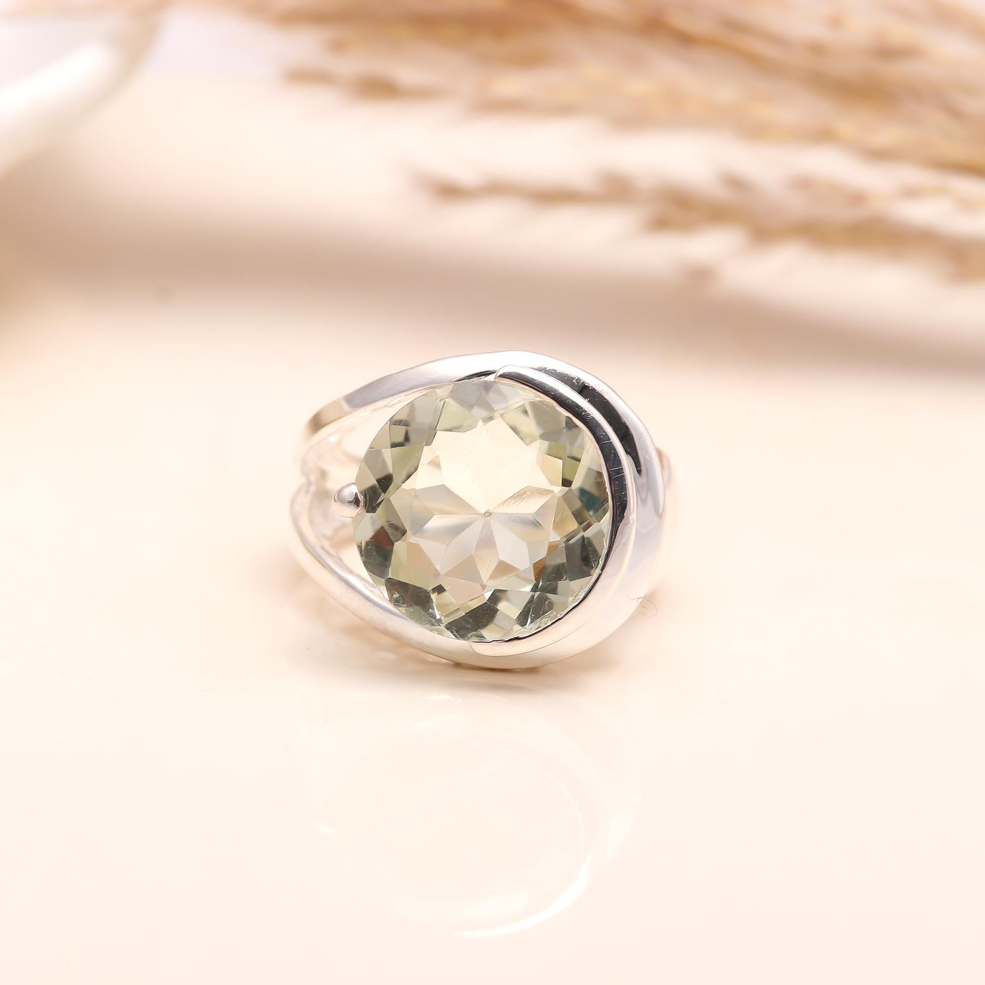 Close-up of round green amethyst with crossover silver band